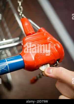 Hand des Mannes Entriegelung Lockeck Trolley im Supermarkt für Lebensmittel einkaufen Stockfoto