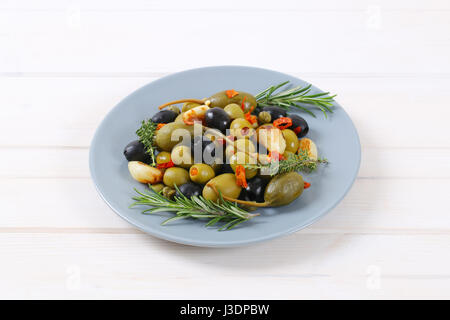 Teller mit grünen und schwarzen Oliven mit Knoblauch, Kapern und Kapern Beeren Stockfoto