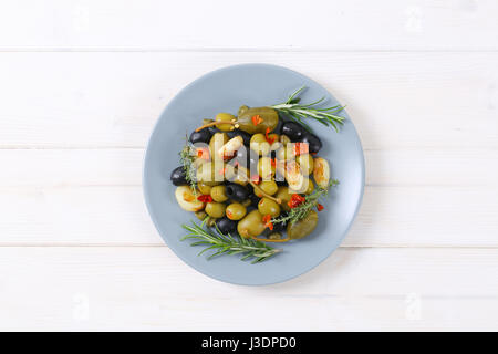 Teller mit grünen und schwarzen Oliven mit Knoblauch, Kapern und Kapern Beeren Stockfoto