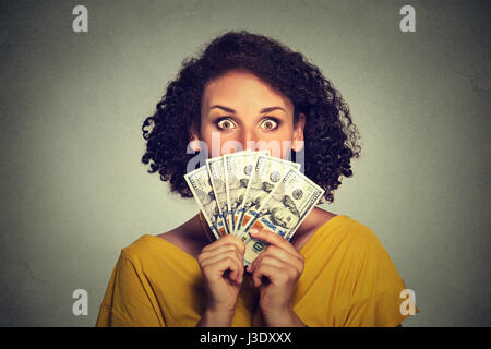 Angst aussehende Frau versteckt Kommissionierung durch Dollar-Banknoten Stockfoto