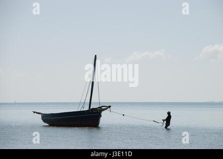 Fischer mit seinem traditionellen Dhau-Fischerboot in Vilanculos, Inhambane Provinz, Mosambik, Südafrika. Stockfoto