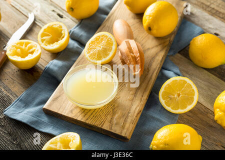 Rohe organische gelbe Zitronensaft in eine Schüssel geben Stockfoto