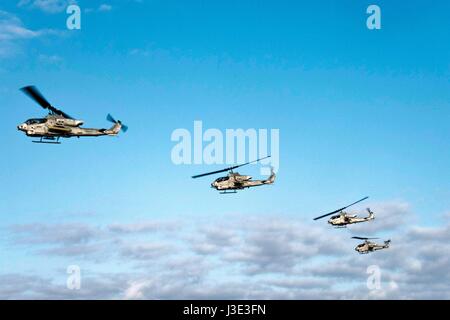 Vier USMC AH-1W Super Cobra Kampfhubschrauber fliegen in Formation über die Bucht von Buckner 5. April 2017 im Pazifischen Ozean.    (Foto von MCS1 Chris Williamson / US Navy über Planetpix) Stockfoto