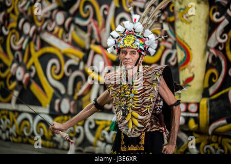 Kenyah Mann führt einen kulturellen Tanz in traditionellen Stammes-Kostüm auf eine einzigartige und unterhaltsame Performance in Pampang Dorf von Kalimantan, Borneo Stockfoto