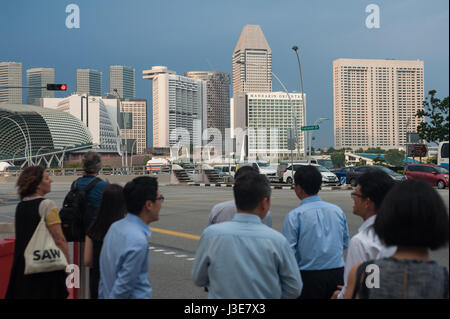 16.03.2017, Singapur, Republik Singapur, Asien - die Menschen warten auf einen Fußgängerüberweg mit Singapurs Skyline im Hintergrund. Stockfoto