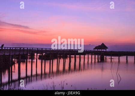 Hölzerne Brücke in Lotus See Sonnenuntergang pünktlich am Khao Sam Roi Yot National Park, Thailand Stockfoto