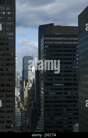 Vogelperspektive von Manhattan, New York City 40th Street urban Canyon an einem teilweise bewölkten Tag. Einige Gebäude beleuchtet von Sonne, einige in dunklen Schatten. Stockfoto