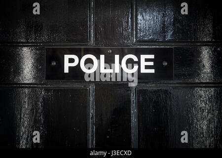 Polizei melden Sie auf schwarzen Tür am Eingang zur Polizei-station Stockfoto
