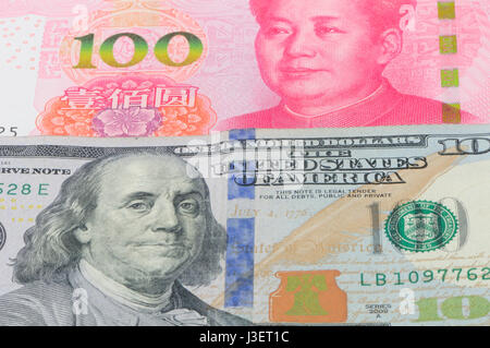 Chinesische Renminbi 100 und 100 US-Dollar Rechnungen gestapelt auf einem weißen Hintergrund. Stockfoto