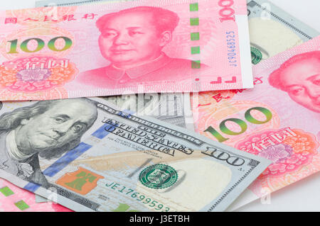 Chinesische Renminbi 100 und 100 US-Dollar Rechnungen gestapelt auf einem weißen Hintergrund. Stockfoto