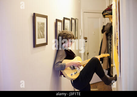 Junge Frau, eine Gitarre zu spielen Stockfoto