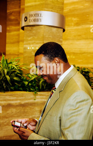 Miami Florida, InterContinental, Hotel, schwarze Männer, Männer, Smartphone-Handys, Lesen von SMS-Nachrichten, Lobby, Gast, prüft mes Stockfoto