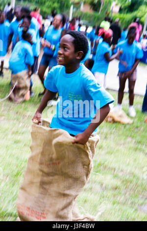 Miami Florida, Little Haiti, Range Park, Back to School Black Boy Jungen, männlich Kind Kinder Kind Kinder Youngster, Sack Rennen, konkurrieren, teilnehmen, spielen, Spiel Inn Stockfoto