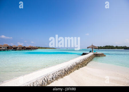 Tropische Insel-Paradies mit Blick über Wasser-Bungalows mit kristallklarem türkisfarbenem Wasser mit White Sand Beach Stockfoto