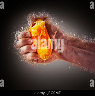 Frisch gepresster Orangensaft durch männliche Hand und Saft fallen zerschlagen Stockfoto