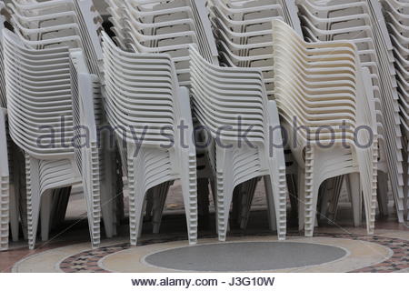 Weiße Kunststoff-Stühle übereinander gestapelt werden, bevor ein Ereignis Stockfoto