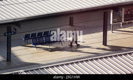 Leeds, England, Großbritannien - 28 Juni 2015: ein Mann geht eine Plattform am Bahnhof Leeds, beleuchtet am Abend Licht, aus einem hohen Winkel gesehen. Stockfoto