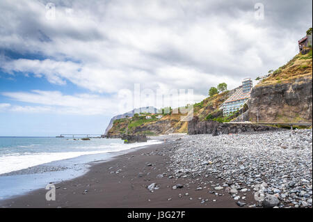 Felsig und dunklen Sandstrand in Funchal auf der Südküste von Madeira. Stockfoto