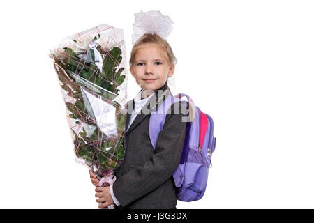 Erstklässler mit einem Blumenstrauß. Fröhliche Mädchen geht zuerst in die Schule zu lernen. Stockfoto