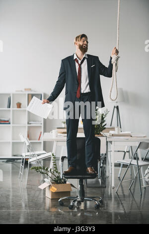 Depressive Jugendliche abgefeuert Geschäftsmann auf Stuhl stehen und versuchen, sich aufzuhängen Stockfoto