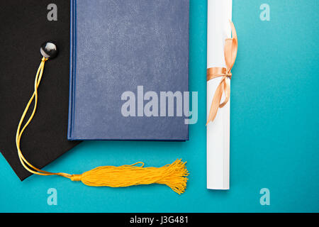 Draufsicht des Buches, Graduation Cap und Diplom auf blau, Bildungskonzept Stockfoto