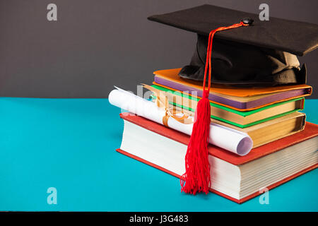 Bücher, Diplom und Promotion Cap mit Quaste auf blau mit Textfreiraum, Bildungskonzept Stockfoto