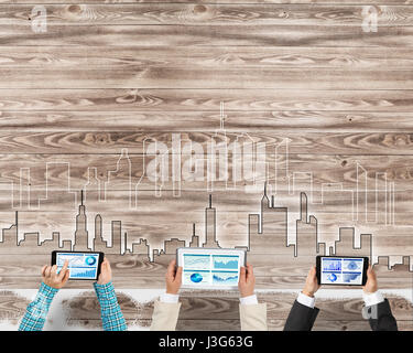 Gruppe von drei Personen mit Geräten in Händen arbeiten zusammen als Symbol der Vernetzung und Kommunikation Stockfoto