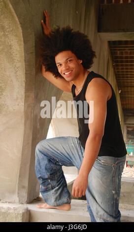 Junger Mann mit Afro-Frisur am Strand Stockfoto