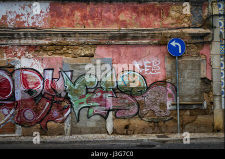 Linkskurve Straßenschild vor einem alten verlassenen Gebäude mit Graffiti bedeckt. Stockfoto