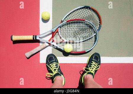 Tennis-Konzept mit zwei Schlägern, Bällen und Spieler Beine. Sport-Hintergrund Stockfoto