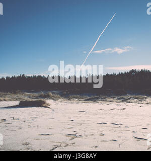 gefrorene Meeresstrand mit blauem Himmel und Schnee bedeckten Strecken - Retro-Vintage-Effekt Stockfoto