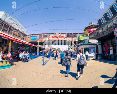 San Francisco, CA, USA - 3. April 2017: Touristen nahe dem Eingang des Pier 39, Fishermans Wharf, Brücke mit Bubba Gump Shrimp Co. unterzeichnen oben Stockfoto