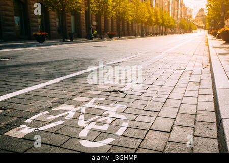 Bycycle Straßenschild, Straßenmarkierung der Radweg entlang der Avenue oder Street In der City an einem sonnigen Vormittag oder Abend bei Sonnenauf- oder Sonnenuntergang. Konzept des Radsports Stockfoto