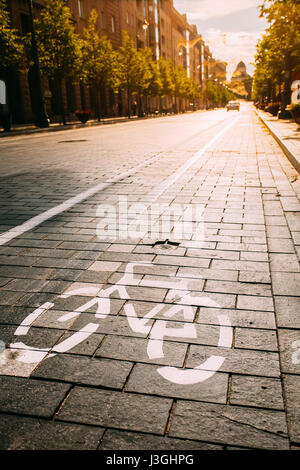 Bycycle Straßenschild, Straßenmarkierung der Radweg entlang der Avenue oder Street In der City an einem sonnigen Vormittag oder Abend bei Sonnenauf- oder Sonnenuntergang. Konzept des Radsports Stockfoto