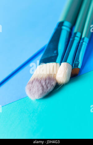 Ihr Leben in Shades of Blue: Stillleben mit einem Make-up-Pinsel platziert auf einem Multi-Ton-Schattierungen von blau. Stockfoto