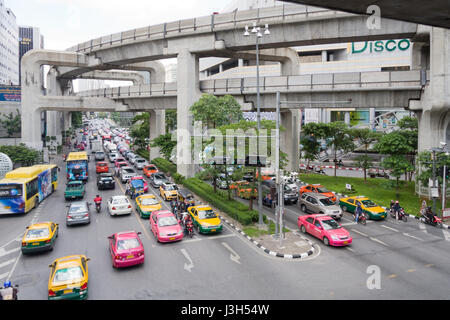 Beschäftigt Bangkok Verkehr auf Phaya Thai Straße mit dem Skytrain Track Overhead, Bangkok, Thailand Stockfoto