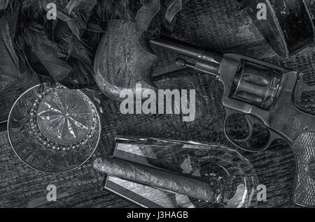 Thompson-Pistole, Revolver, Zigarren Aschenbecher, Whiskeyglas und blaue Federboa. Schwarz / weiß Stockfoto