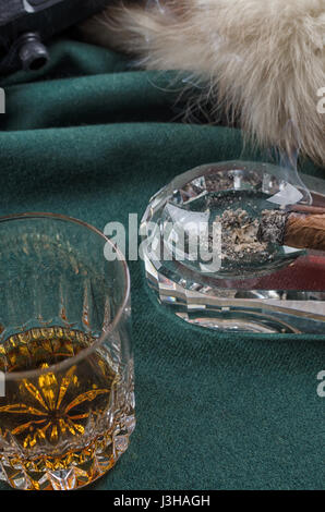 Thompson-Pistole, Revolver, Zigarren Aschenbecher, Whiskeyglas und Fell Stockfoto