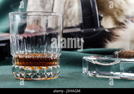 Thompson-Pistole, Revolver, Zigarren Aschenbecher, Whiskeyglas und Fell Stockfoto