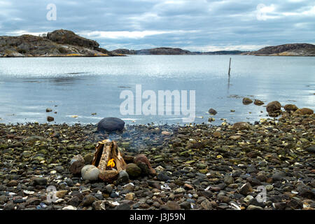 Lagerfeuer am felsigen Strand Stockfoto