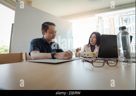 Asiatische Geschäftsfrau diskutieren und Brainstorming mit freier Jüngling im Tagungsraum. Start Brainstorming und Teamwork Geschäftskonzept Stockfoto