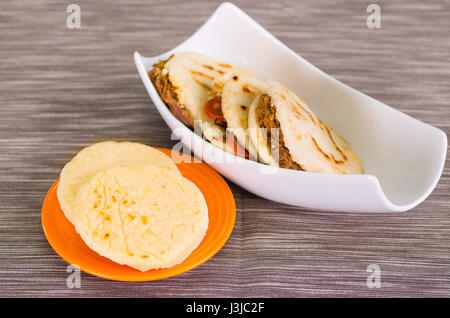 Traditionelle leckere Arepas, Hühnerfleisch Avocado und Cheddar-Käse und Hackfleisch auf hölzernen Hintergrund. Stockfoto