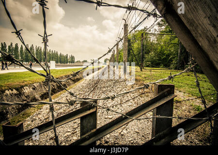 Dachau, Deutschland - 30. Juli 2015: Ein Blick durch Stacheldraht, Graben und Zaun Montage aller Konzentrationslager. Stockfoto