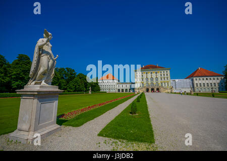 Nymphenburg, Deutschland - 30. Juli 2015: Schöne Palast wie aus Entfernung mit Statuen auf beiden Seiten der Allee bis zum Gebäude. Stockfoto