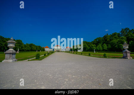 Nymphenburg, Deutschland - 30. Juli 2015: Schöne Palast wie aus Entfernung mit Statuen auf beiden Seiten der Allee bis zum Gebäude. Stockfoto