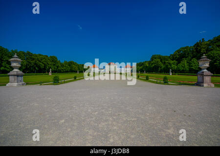 Nymphenburg, Deutschland - 30. Juli 2015: Schöne Palast wie aus Entfernung mit Statuen auf beiden Seiten der Allee bis zum Gebäude. Stockfoto