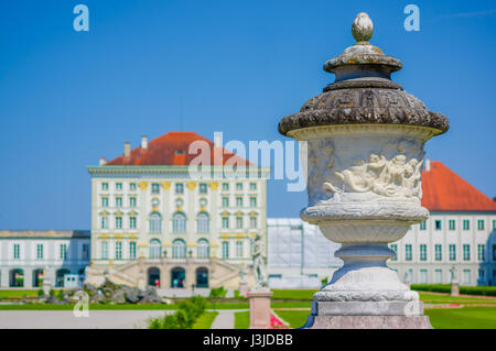 Nymphenburg, Deutschland - 30. Juli 2015: Palastgebäude Schuss aus künstlerischen Blickwinkel mit Skulptur aus nächster Nähe sichtbar, grass schönen blauen Himmel und grüne con Stockfoto