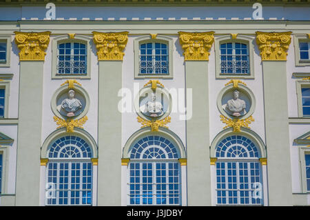 Nymphenburg, Deutschland - 30. Juli 2015: Closeup Palast Fassade mit großen Fenstern und mehrere Büste Skulpturen mit goldenen Ornamenten Dekorationen. Stockfoto