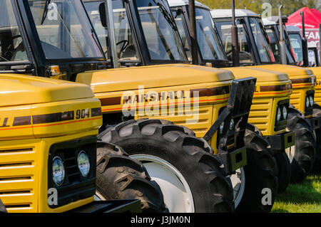 Reihe von gelben Marshall Traktoren bei einer Landwirtschaftsausstellung. Stockfoto