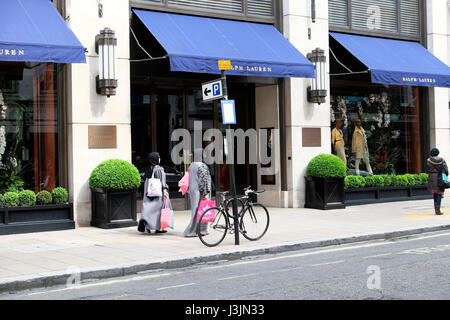 Muslimische Frauen Shopper in Hijabs mit Einkaufstüten zu Fuß vorbei an amerikanischen Ralph Lauren Store in New Bond Street, Mayfair, London W1S KATHY DEWITT Stockfoto